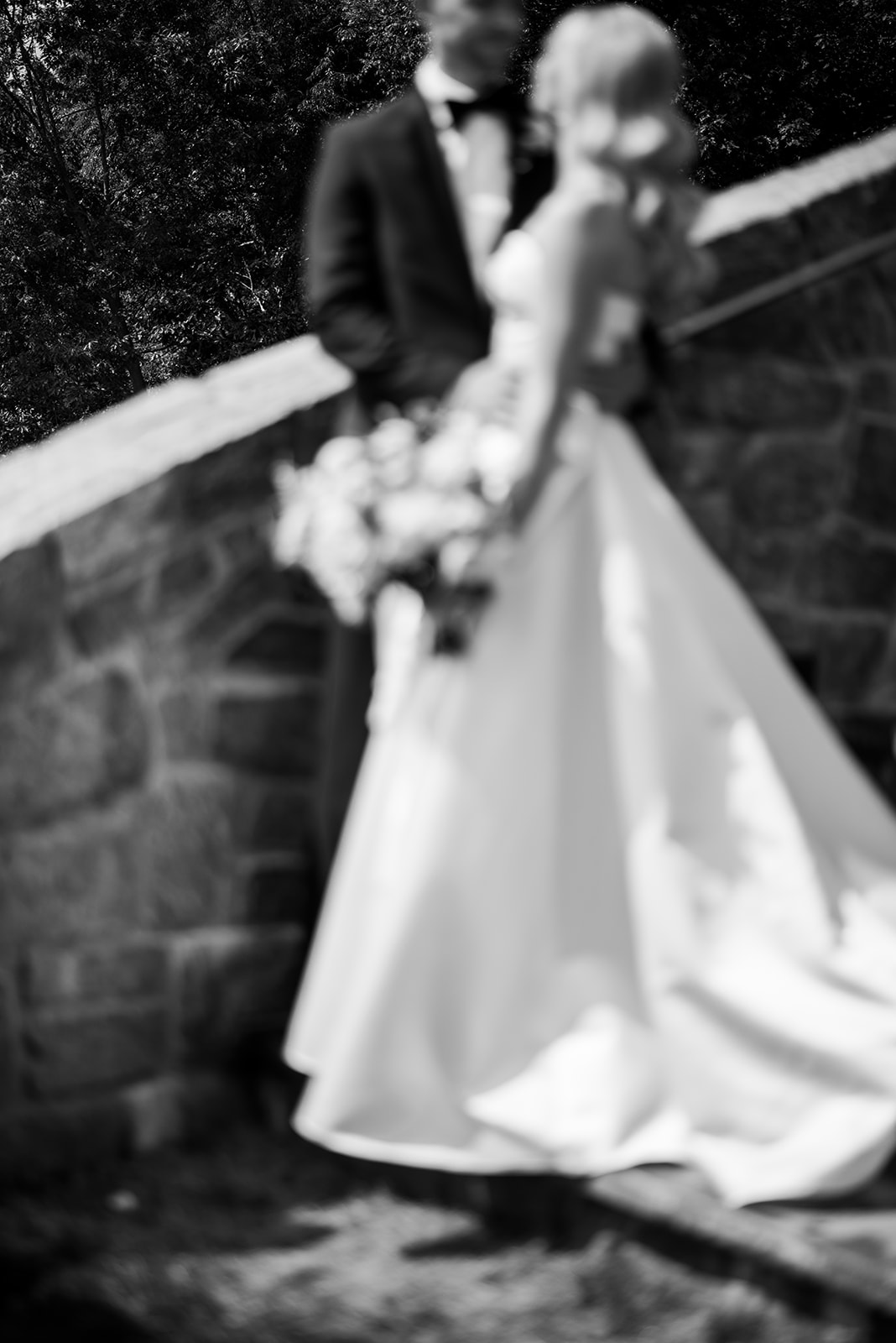 Close-up of bride and groom kissing beneath a veil