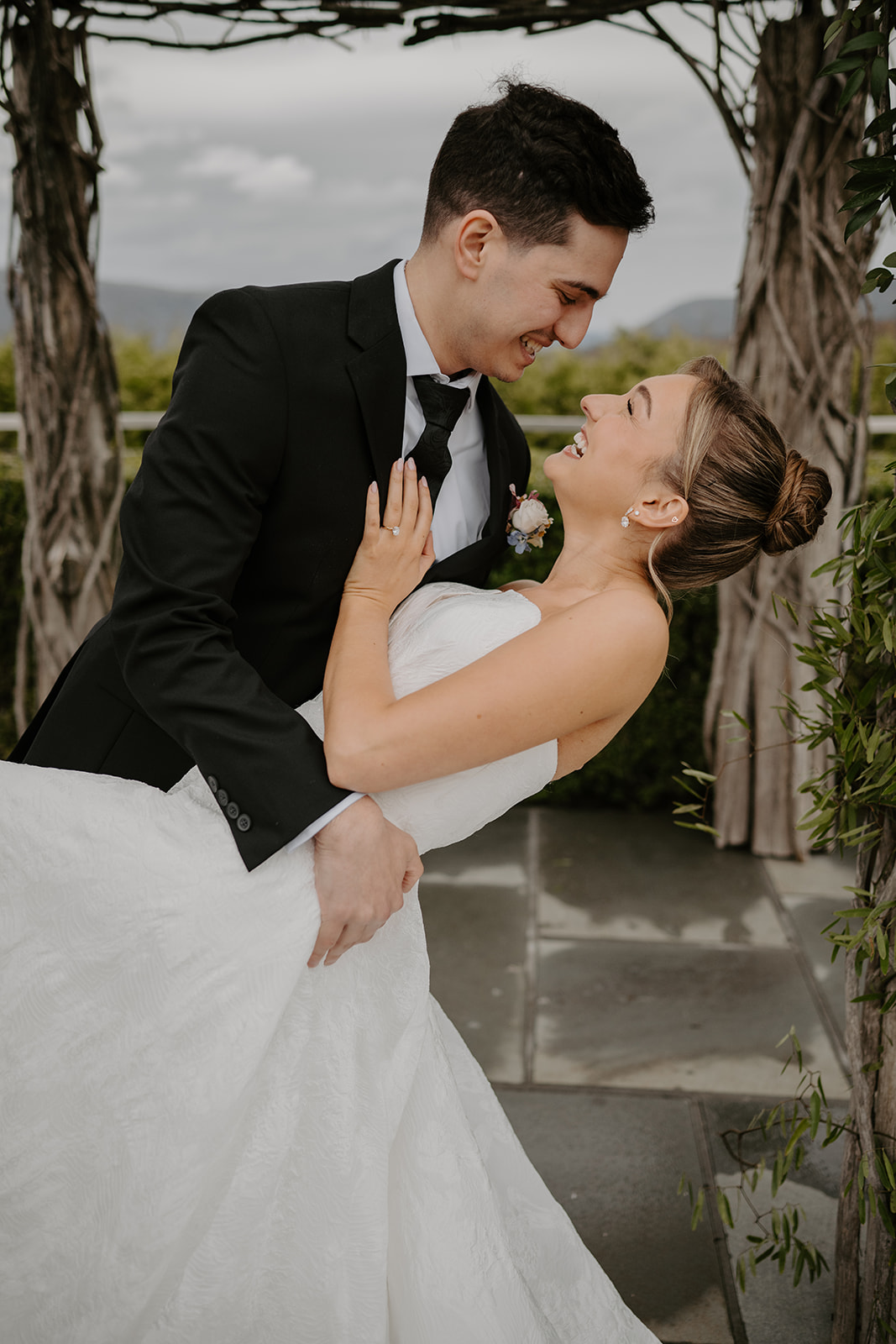 Close-up color photo of the dip under the arch, showing both of them laughing and looking at each other.