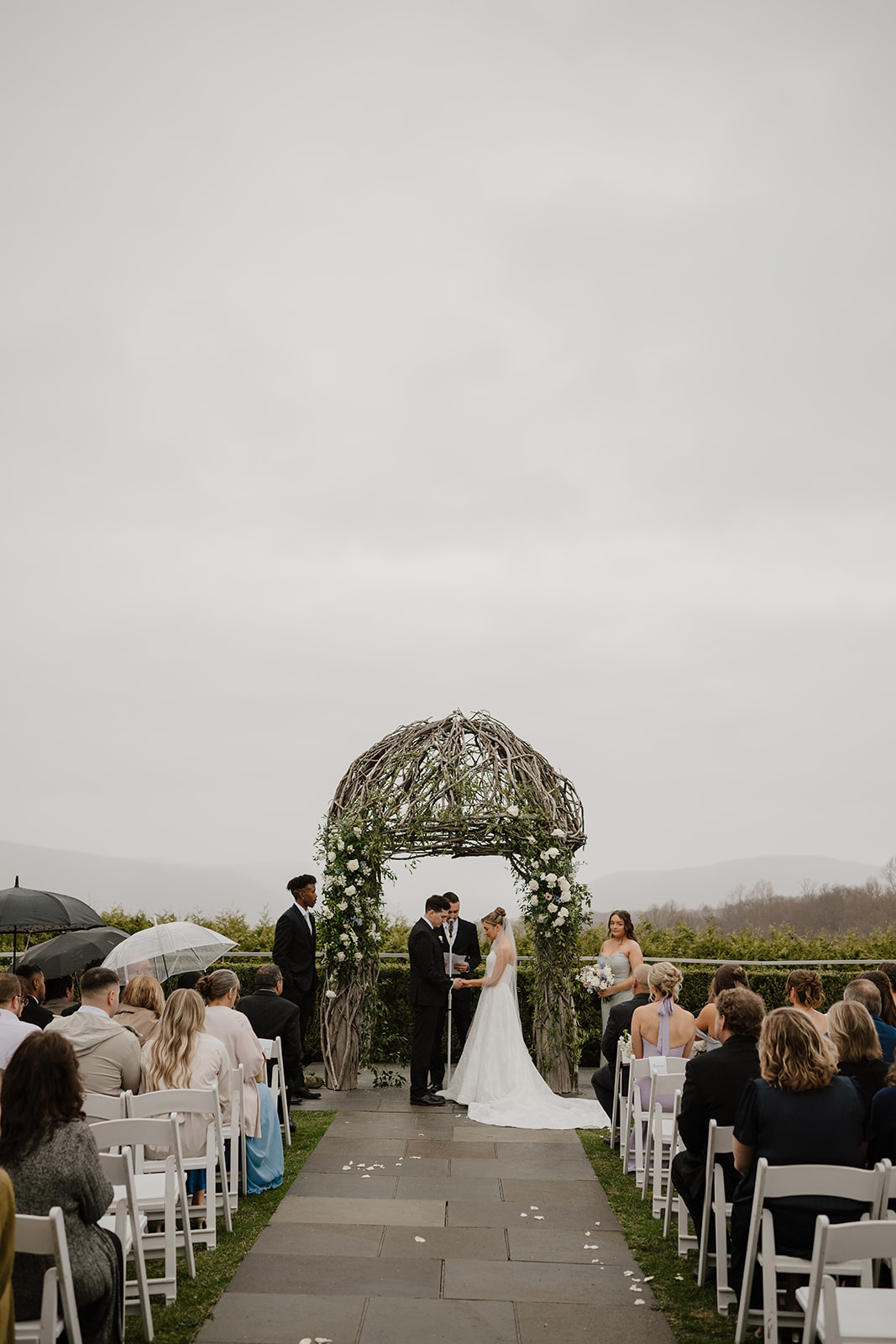 Panoramic view of the outdoor wedding ceremony in progress at The Garrison, overlooking the Hudson River and Highlands.