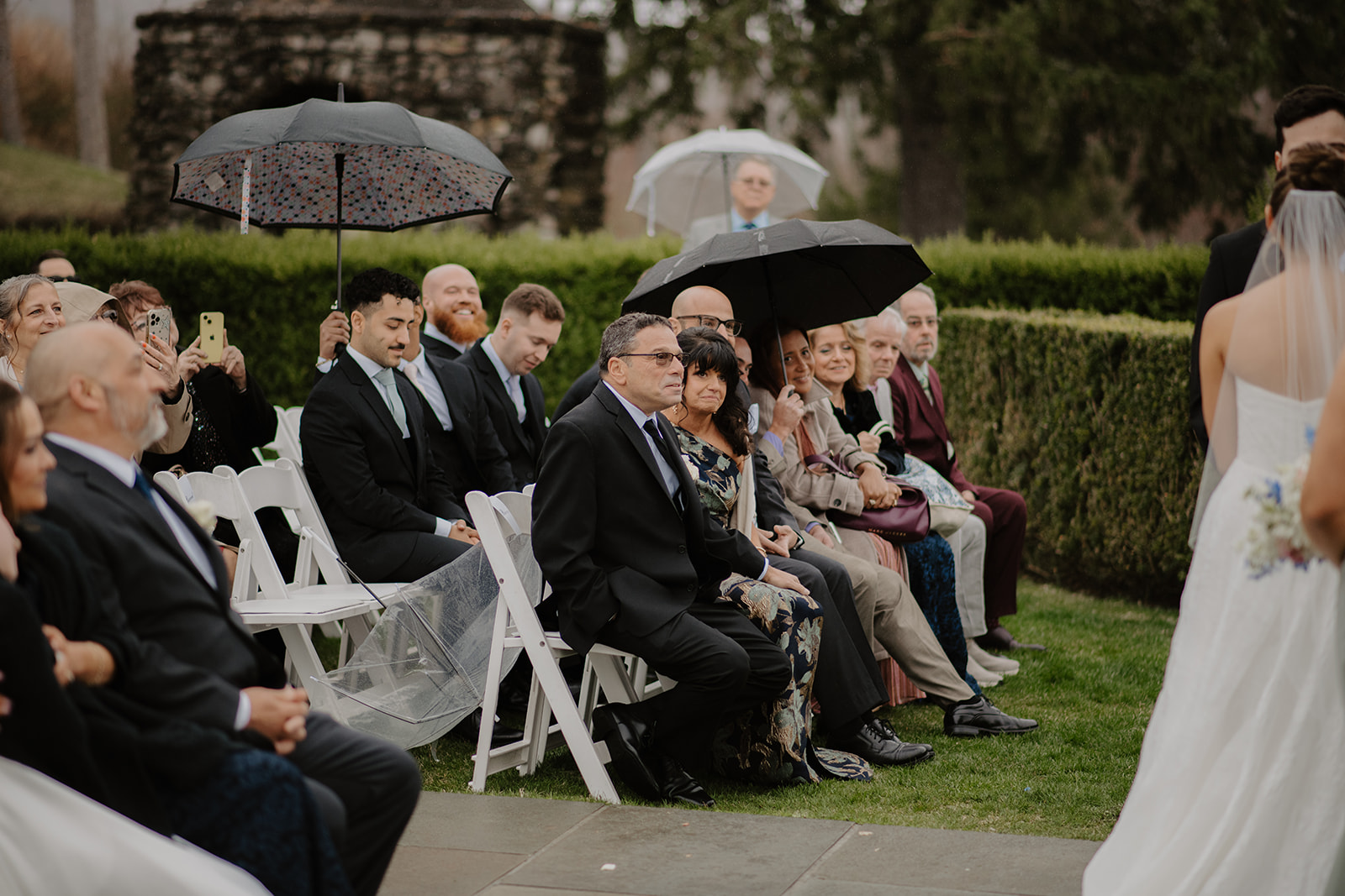 Parents and wedding guests seated, watching the ceremony.
