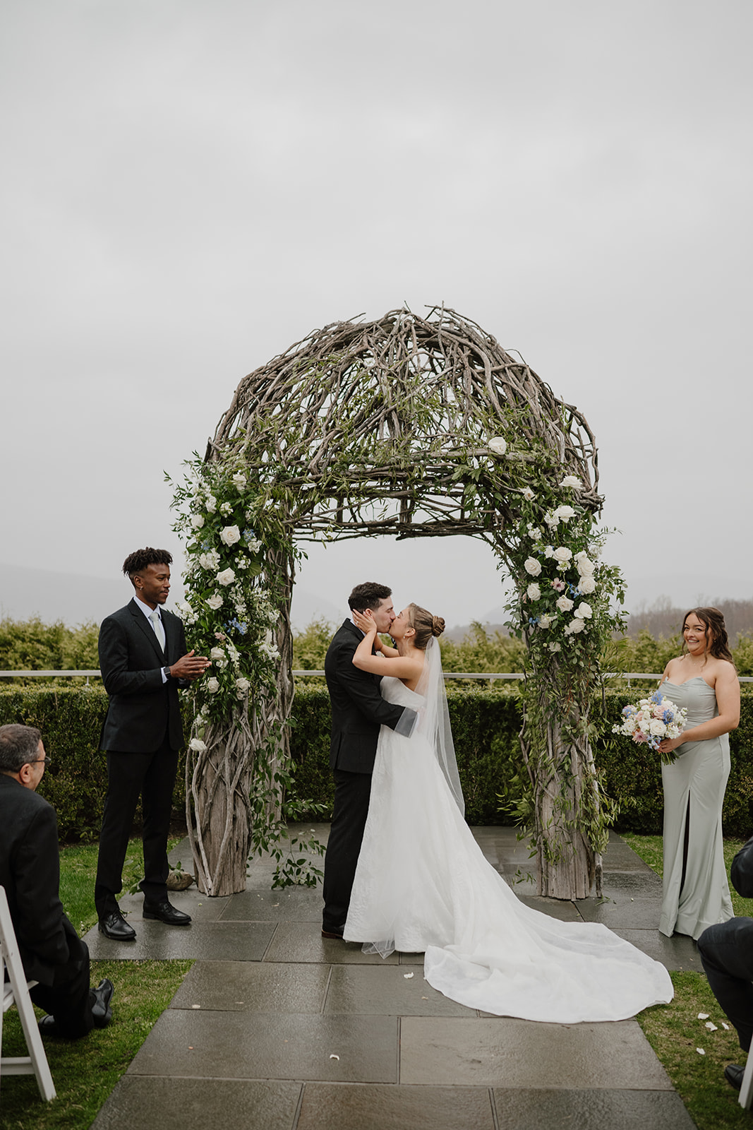 Newlyweds sharing their first kiss under the ceremony arch at The Garrison.