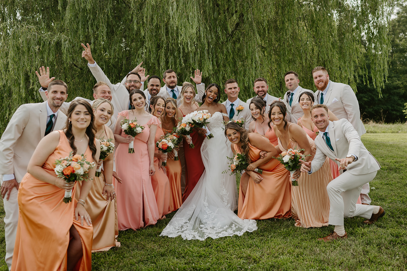 Bride and groom celebrate with their full bridal party under the willow tree.