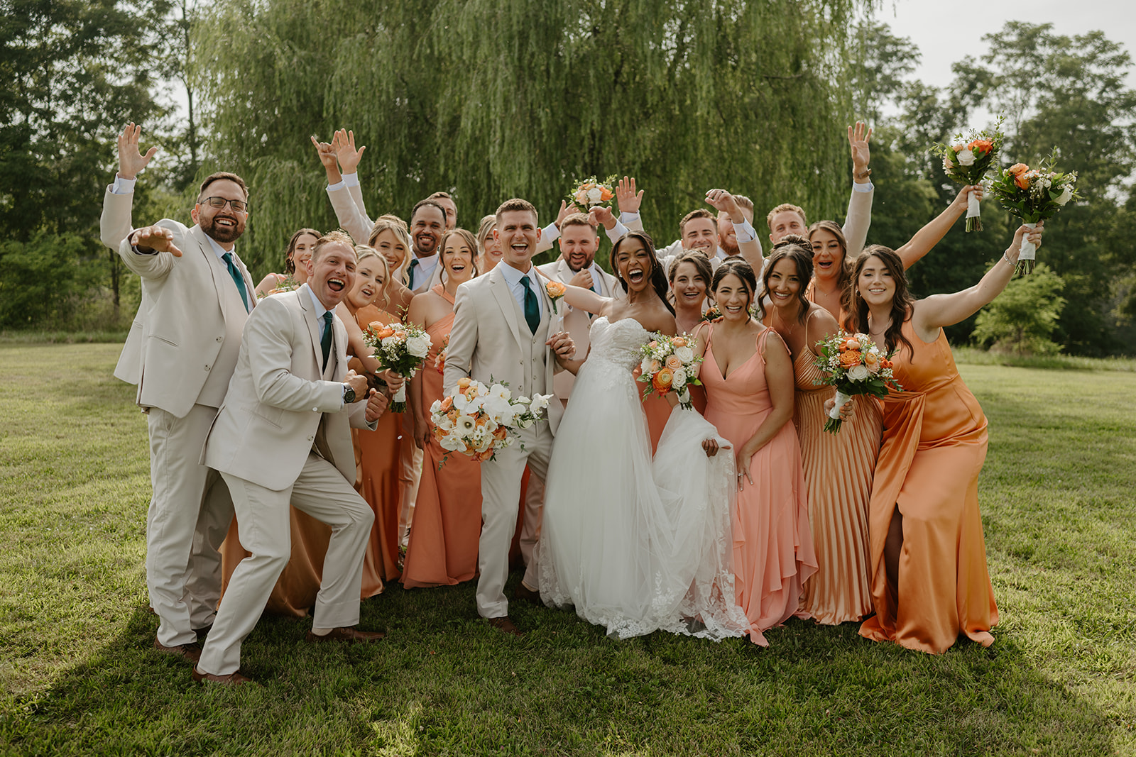 Bridal party throws their hands up in celebration around the newlyweds.