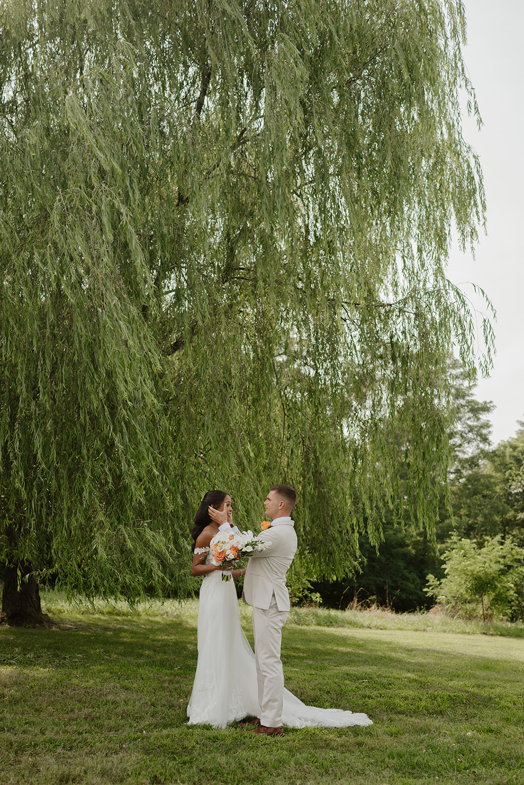 Bride and groom share a quiet moment under the sweeping willow tree.