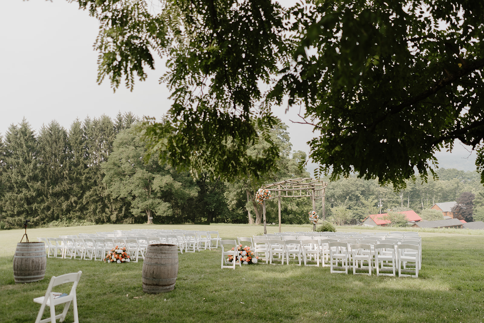 White ceremony chairs and wine barrels set out on the lawn before the ceremony.