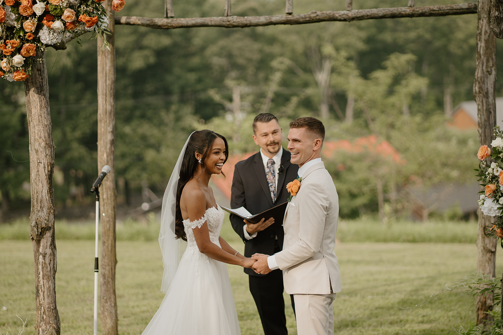 Bride and groom hold hands at the altar as their officiant reads.