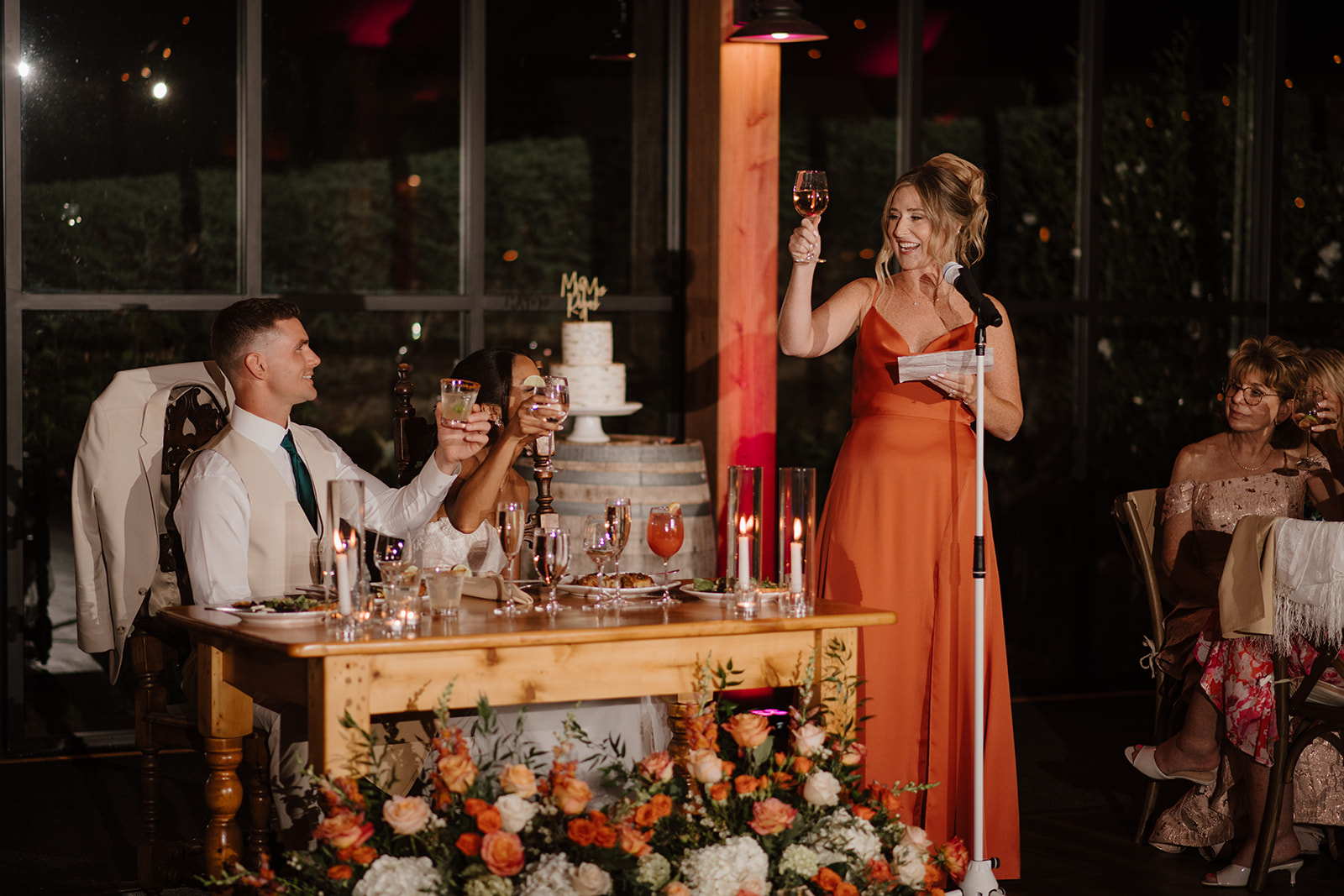 Guests raise their glasses to the newlyweds during the reception toasts.